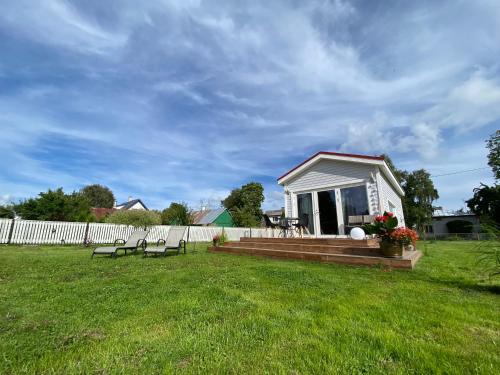 a tiny house in a yard with two chairs at Elo Külalismaja in Kuressaare