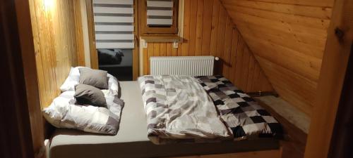 1 dormitorio con 1 cama en una cabaña de madera en Domek na kurzej stópce, en Grzechynia