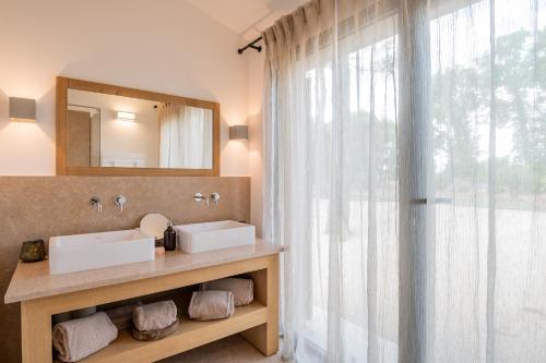 ein Badezimmer mit 2 Waschbecken und einem Spiegel in der Unterkunft Bastidon du Domaine de La Julienne in Tourves