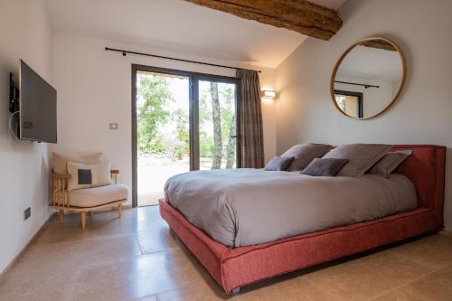 ein Schlafzimmer mit einem großen Bett und einem Spiegel in der Unterkunft Bastidon du Domaine de La Julienne in Tourves