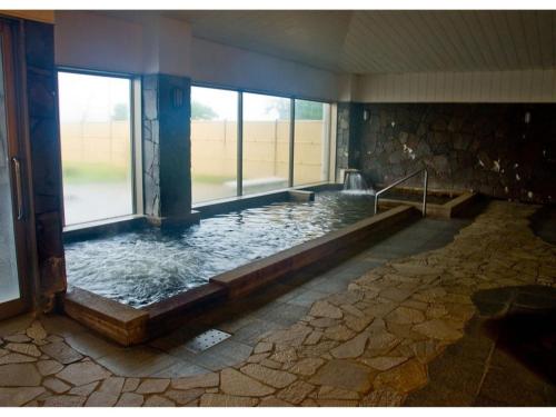 a large pool of water in a room with windows at Hitoyoshi Onsen Hotel Hananoshou - Vacation STAY 40096v in Hitoyoshi