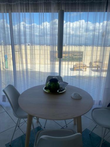 a table with a plate of fruit on it in front of a window at Exclusive view ocean in Natanya the sea promenade in Netanya