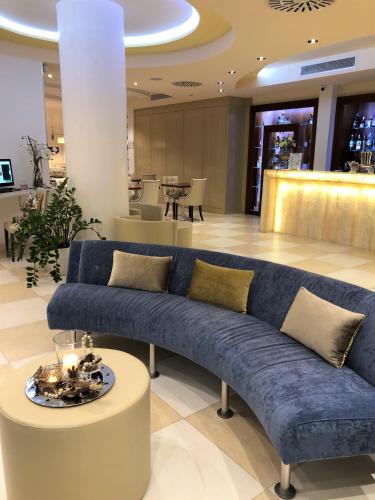 a living room with a blue couch and a table at Erbavoglio Hotel in Rimini