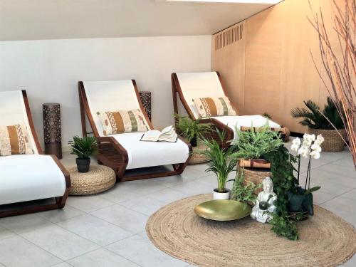 a room with three beds and a table with plants at Erbavoglio Hotel in Rimini