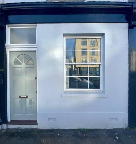 a white building with a door and two windows at 64 Bath Road - Central to Cheltenham in Cheltenham