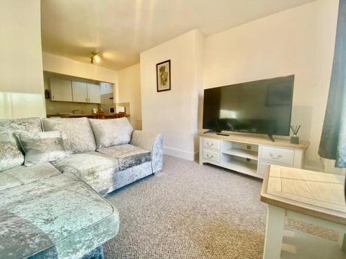 een woonkamer met een bank en een flatscreen-tv bij 64 Bath Road - Central to Cheltenham in Cheltenham