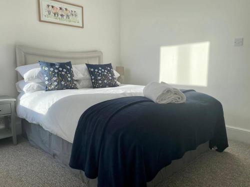 a bedroom with a bed with a blue blanket on it at 64 Bath Road - Central to Cheltenham in Cheltenham