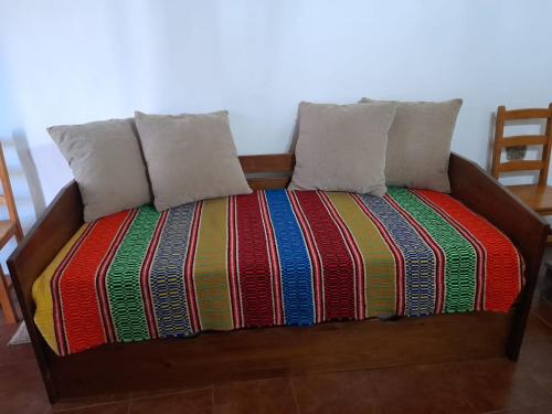 a bed with two pillows and a colorful blanket at Casa do Celeiro - Monsaraz in Monsaraz
