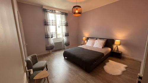 1 dormitorio con 1 cama, 1 silla y 1 ventana en Appartement T4 70m2 - meublé - centre ville - proche Thermes, en Lons-le-Saunier