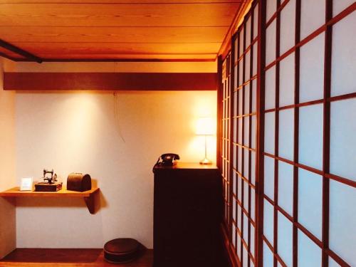 Cette chambre dispose d'une table avec une lampe et d'un téléphone. dans l'établissement Nara Ryokan - Vacation STAY 49570v, à Nara