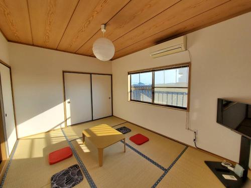 a living room with a table and a television at Ocean View Kamogawa - Vacation STAY 61073v in Kamogawa