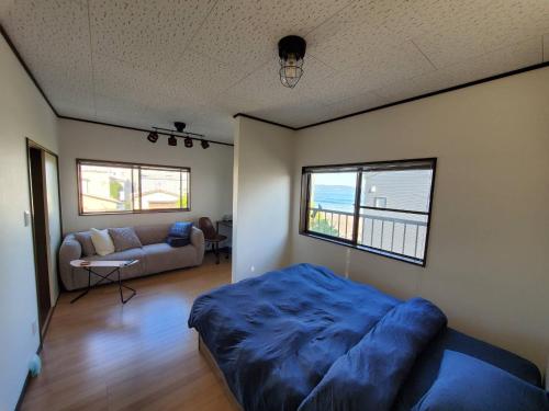 a bedroom with a bed and a living room with a couch at Ocean View Kamogawa - Vacation STAY 61073v in Kamogawa