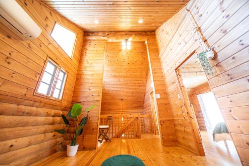 Cette chambre se trouve dans une maison en bois dotée de murs en bois. dans l'établissement Awaji Large Loghouse in Goshiki - Vacation STAY 64354v, à Sumoto