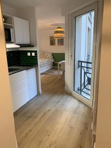 une cuisine avec des placards blancs et une grande porte coulissante en verre. dans l'établissement Nantes Bouffay STUDIO Les machines de l'île, à Nantes