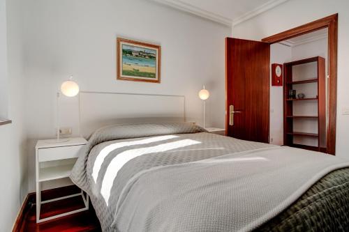 1 dormitorio con 1 cama, armario y puerta en Luminoso apartamento en el centro de Hondarribia en Hondarribia