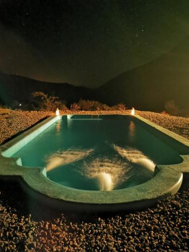 a hot tub in the middle of the desert at night at Cabaña Alma de Montaña, piscina privada in Monte Grande