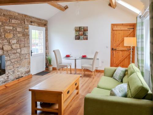 un soggiorno con divano verde e tavolo di The Fauld a Gilsland