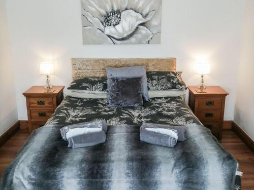 una camera da letto con un grande letto con due comodini di The Fauld a Gilsland