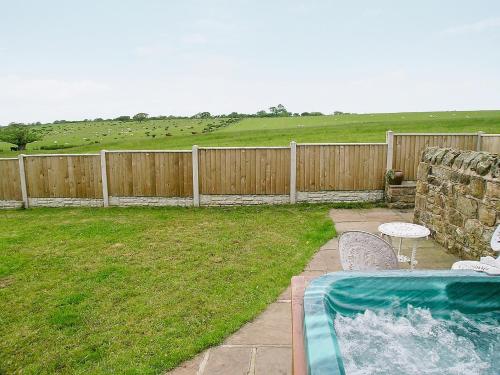 a backyard with a swimming pool and a fence at The Fauld in Gilsland