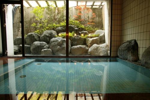 a swimming pool with a view of a garden at Nakaya Ryokan in Minakami