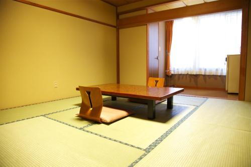 uma sala de jantar com uma mesa e duas cadeiras em Nakaya Ryokan em Minakami