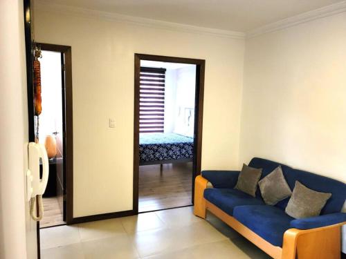 ein Wohnzimmer mit einem blauen Sofa und einem Spiegel in der Unterkunft Lovely 2B-2B Condo in the best area of Cuenca. in Cuenca