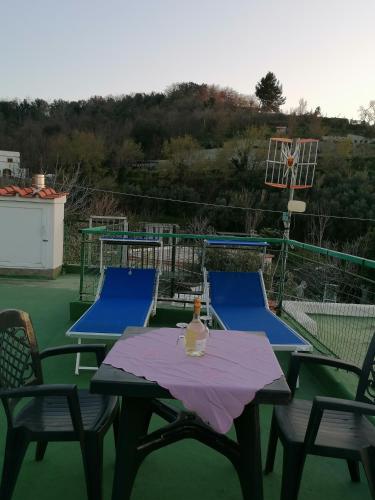 a table and chairs with a bottle of wine on it at CASA VERDE Inn in Ischia