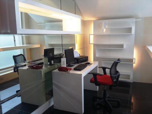 an office with a desk with a computer and two chairs at Zurich Hotel Balikpapan in Balikpapan