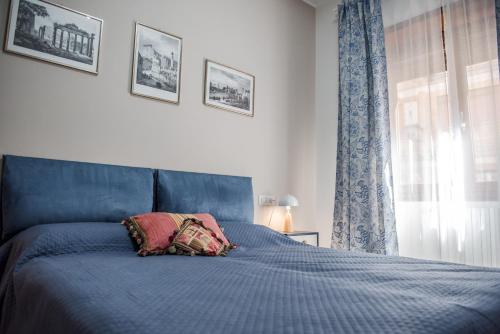 een slaapkamer met een blauw bed met een kussen erop bij Casa 3 Santi, your contemporary home in Rome in Rome