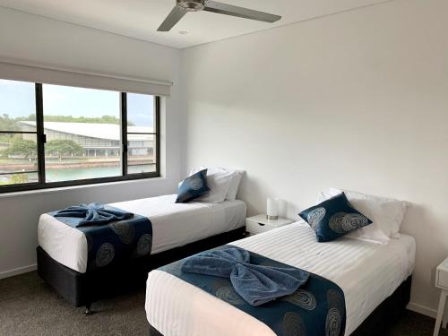 sypialnia z 2 łóżkami i dużym oknem w obiekcie Serenity Splendour at Darwin Waterfront w mieście Darwin
