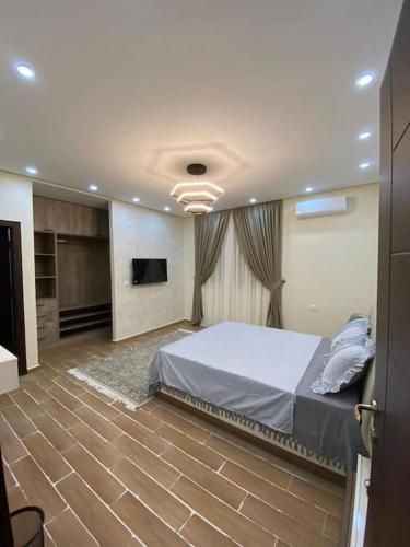 a bedroom with a bed and a television in it at Modern and a touch of royalty in 6th Of October