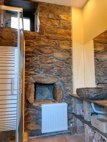 a room with a stone wall with a white radiator at by karakas Γαστρί in Kálamos
