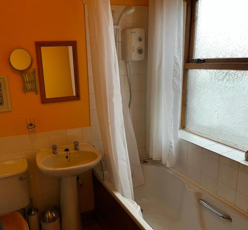 LaurencekirkにあるBloomfield Steadingのバスルーム(洗面台、トイレ、バスタブ付)、窓が備わります。