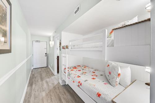 a white bedroom with a white bunk bed at Beach Front 16th Flr, Best Ocean View, New Upgrades in Destin