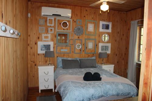 een slaapkamer met een bed en een muur met foto's bij Bush break @ 3990 Marloth Park in Marloth Park
