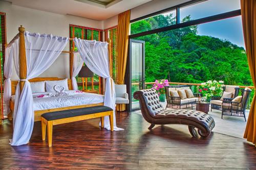 Fully Serviced Grand Villa Luxury Time Phuket في شاطئ بانغ تاو: غرفة نوم بسرير مظلة وكرسي