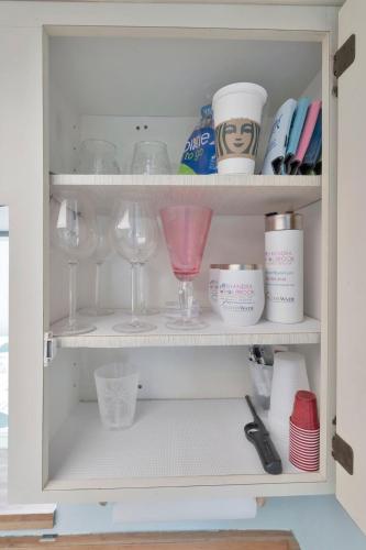 a cupboard filled with wine glasses and other items at Coastal Cheer in Bradenton Beach