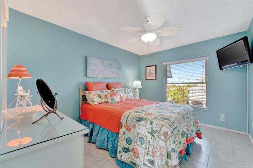 a bedroom with a bed and a flat screen tv at Coastal Cheer in Bradenton Beach