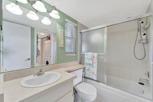 a bathroom with a sink and a shower and a toilet at Coastal Cheer in Bradenton Beach