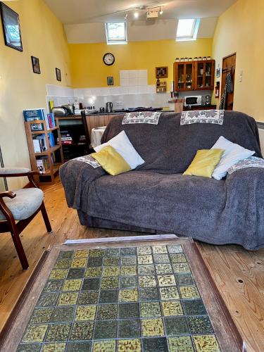 a living room with a couch and a kitchen at Bloomfield Steading in Laurencekirk