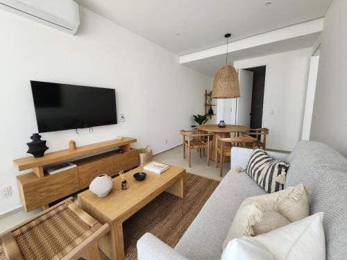a living room with a couch and a tv at Aria Ocean mountain 715B QueridaEstancia in Bucerías