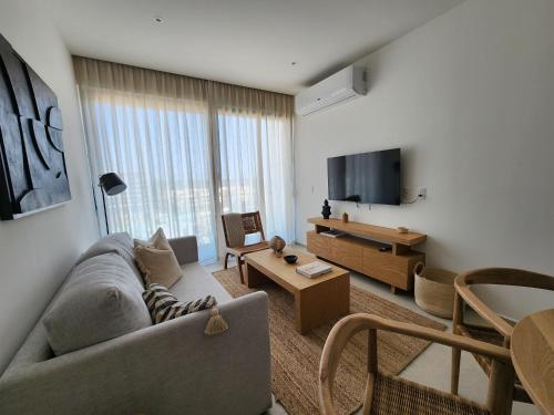 a living room with a couch and a tv at Aria Ocean mountain 715B QueridaEstancia in Bucerías