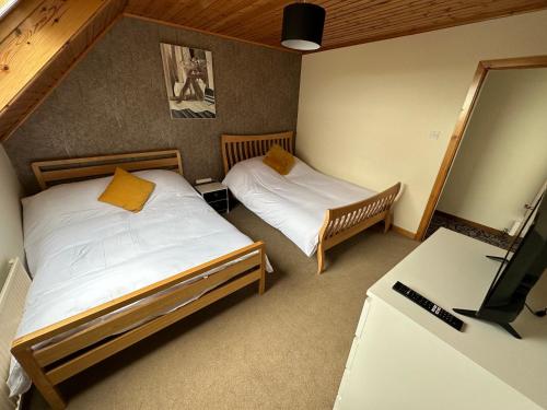 Kleines Zimmer mit 2 Betten und einem TV in der Unterkunft Hill Top House 