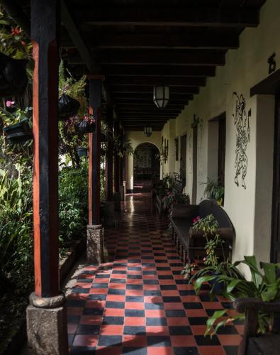 a porch of a house with a checkered floor at Hotel Museo Mayan Inn in Chichicastenango