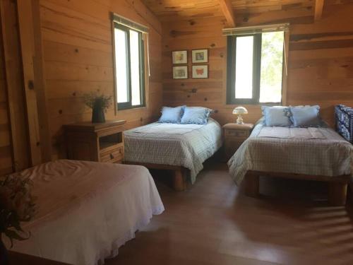 a bedroom with two beds in a log cabin at Preciosa Cabaña de Madera en Valle de Bravo in Valle de Bravo