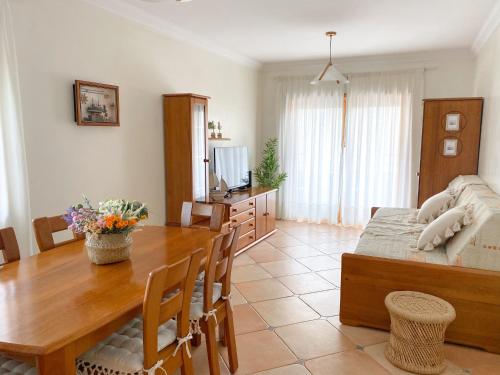 a living room with a wooden table and a dining room at Buzio e Mar in Portimão