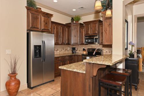a kitchen with wooden cabinets and a stainless steel refrigerator at B11-Red Cliff Suite-Second Floor 3-bedroom Sunset view in Washington