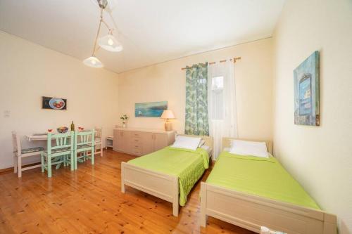 1 Schlafzimmer mit 2 Betten, einem Tisch und einem Tisch in der Unterkunft House of Hapiness in Assos in Asos