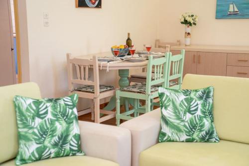 een eetkamer met een tafel en stoelen en een tafel en een stoeltje bij House of Hapiness in Assos in Asos