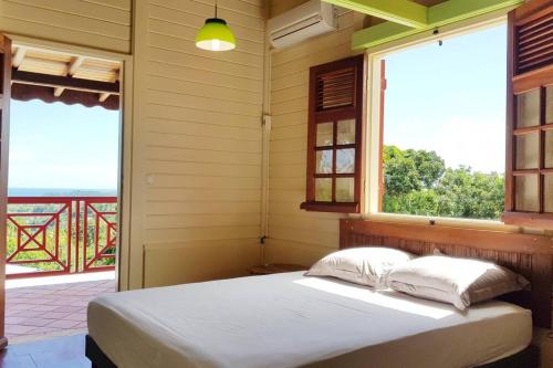 - une chambre avec un lit et une fenêtre avec vue dans l'établissement Idéal groupe : Villa 150m2 + piscine + vue mer, à La Trinité
